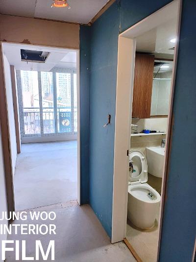 파란 벽과 흰색 문이 있는 복도와 화장실 입구