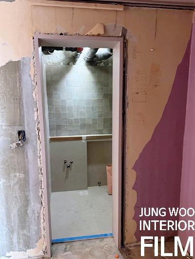 흰색 타일이 보이고 벽면이 철거된 욕실