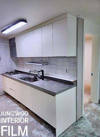 회색 상판과 흰색 수납장이 있는 주방 내부