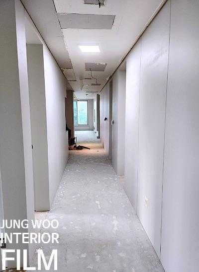 마감이 되지 않은 흰 벽과 콘크리트 바닥의 복도