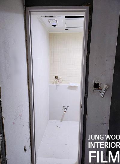 흰색 타일 벽면의 노출 수도관과 전기 박스