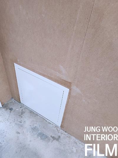 흰색 도어와 주변 벽면의 마감 상태를 점검하는 모습