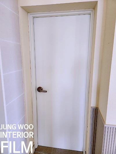 금색 손잡이가 달린 도어와 베이지색 벽면의 현관