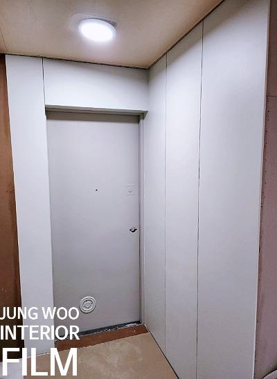 흰색 벽면과 천장, 조명이 보이는 실내 공간