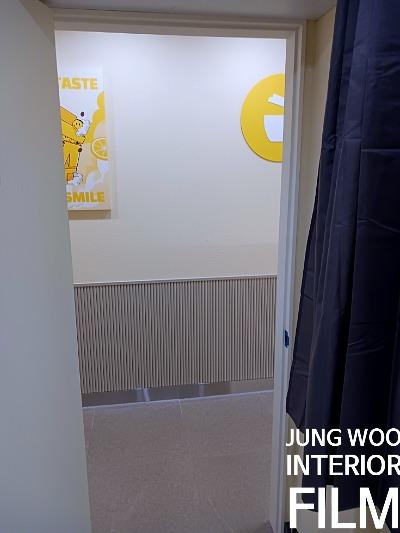 나무 패널과 상단 포스터가 배치된 복도 벽면