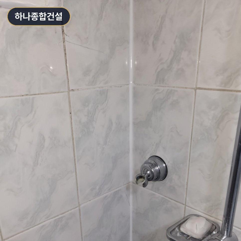 수전과 비누 받침대가 설치된 깔끔한 욕실 벽면