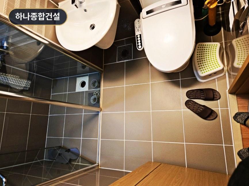 화이트 톤 세면대와 변기로 마감된 화장실 내부