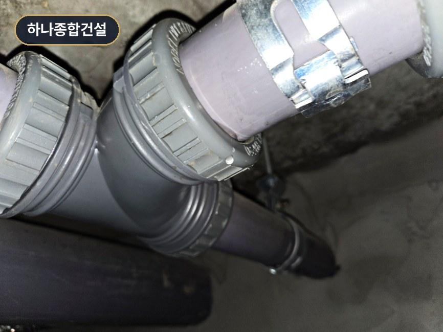 금속 클램프로 고정된 회색 플라스틱 배관