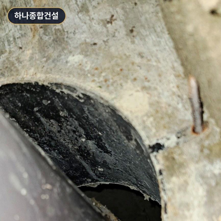 콘크리트 벽면과 검은색 파이프의 연결 지점