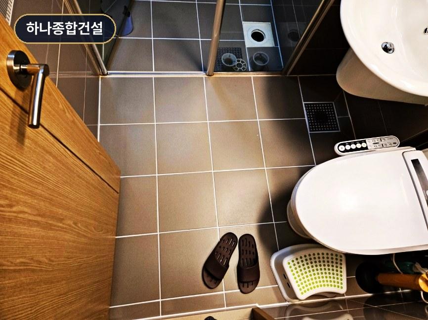 회색 타일과 전자변기가 설치된 깔끔한 욕실 모습