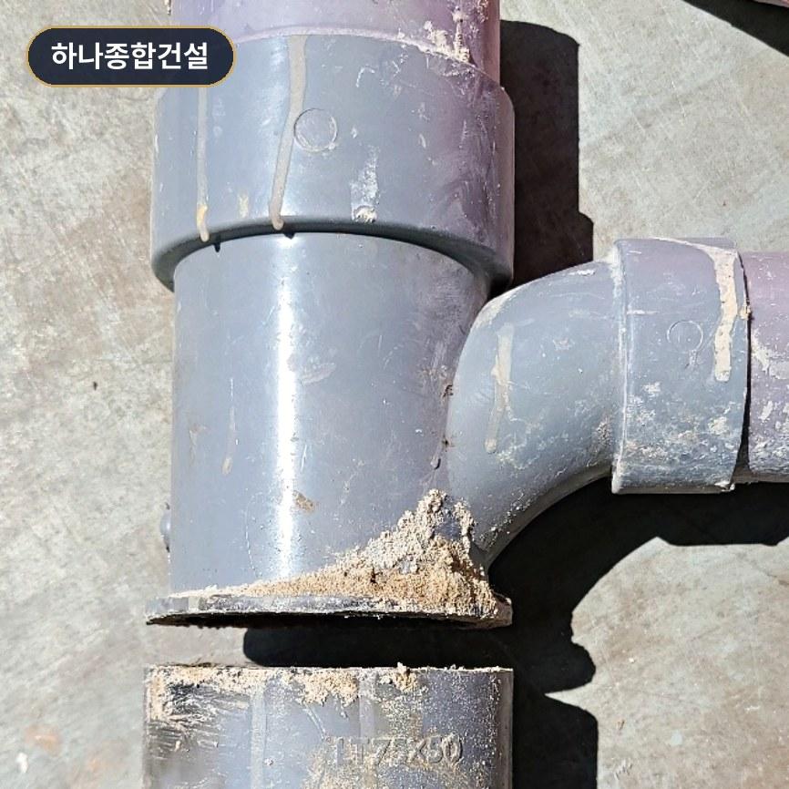 먼지가 쌓인 회색 플라스틱 배관 접합부