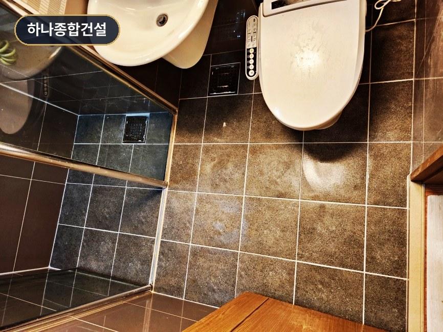 블랙과 브라운 타일이 매치된 샤워 공간 및 화장대