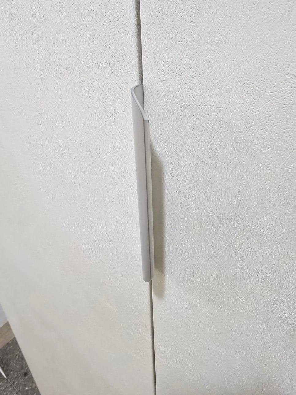 벽면에 부착된 흰색 도어 핸들의 작업 과정