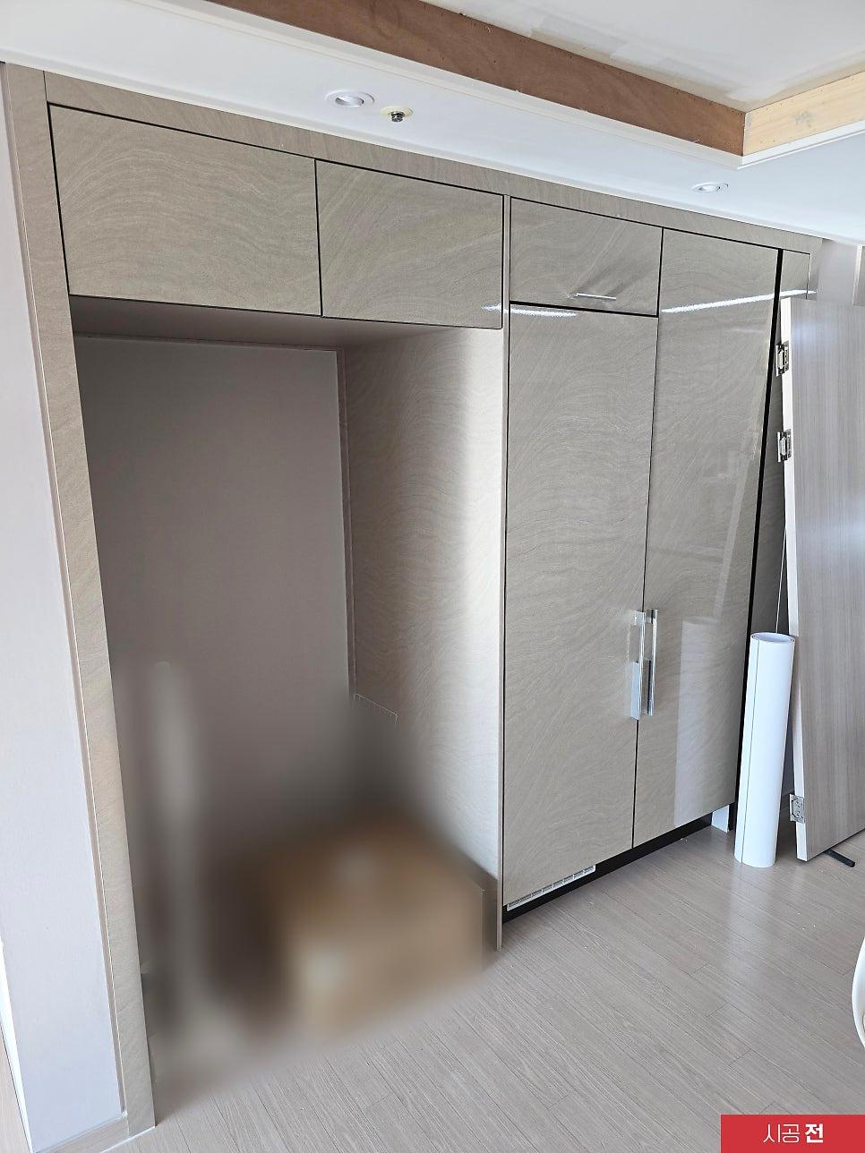 수납장 도어 패널에 필름지를 밀착시키는 시공 과정