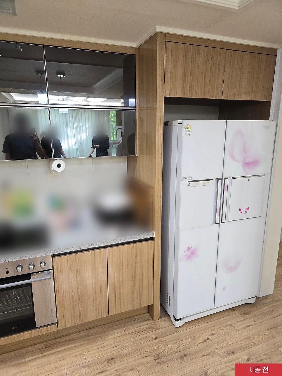 우드톤 수납장과 유리 문짝이 있는 시공 전 주방