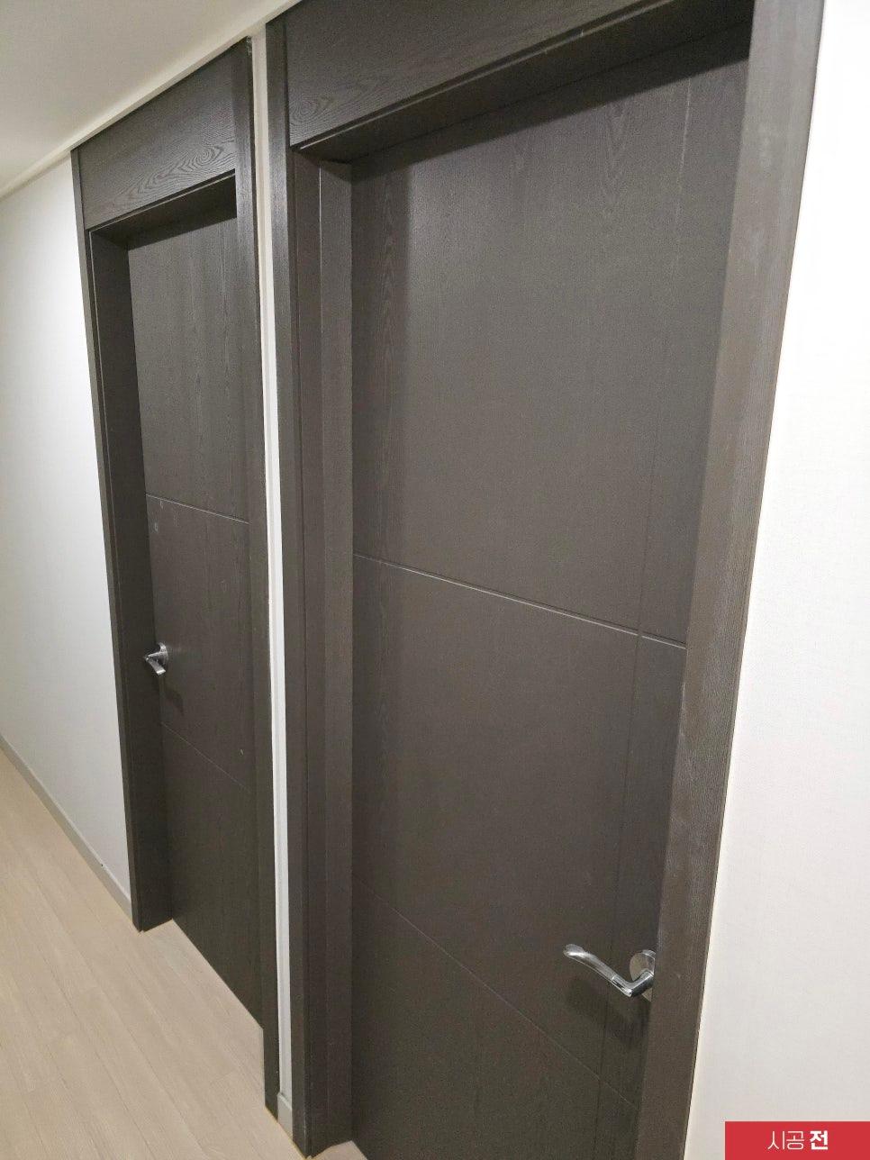 검은색 목재 질감의 도어와 벽면이 있는 복도