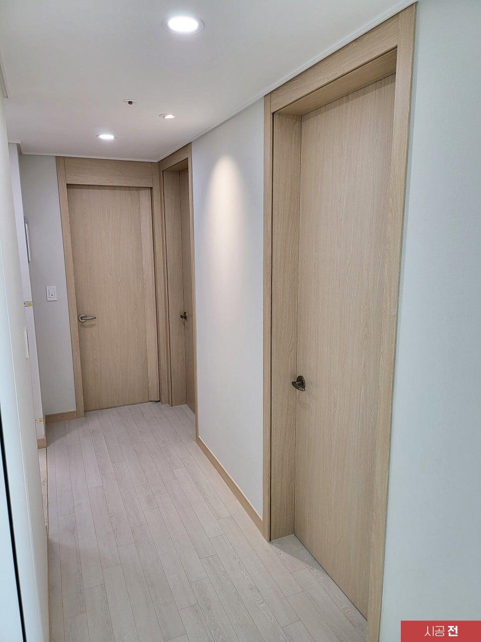 목재 톤의 문과 바닥재가 있는 시공 전 복도