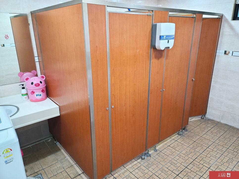 시공 전 체리색 큐비클이 설치된 욕실 모습