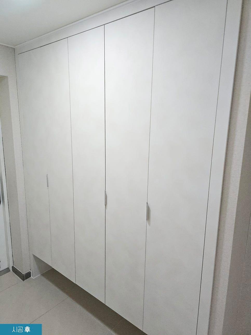 천정과 바닥 타일이 보이는 화이트 수납 공간