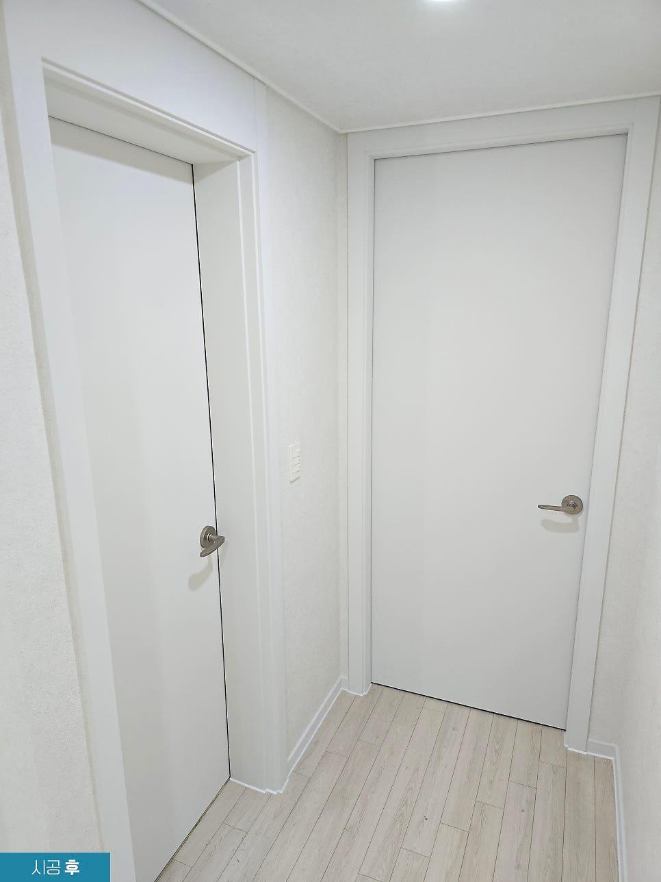 흰색 도어와 벽지로 정돈된 시공 후 복도 전경