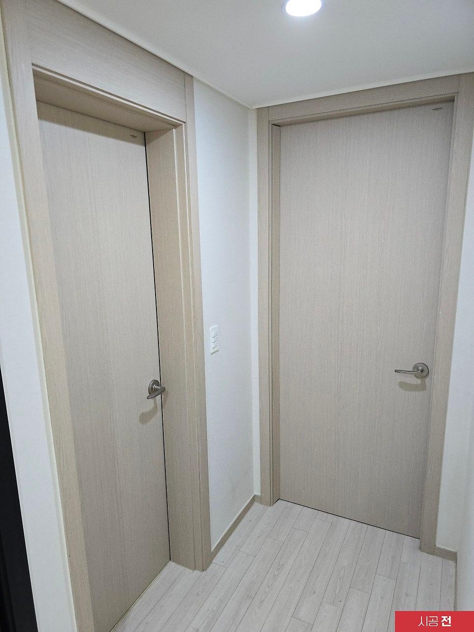 흰 벽면과 우드톤 도어가 배치된 복도