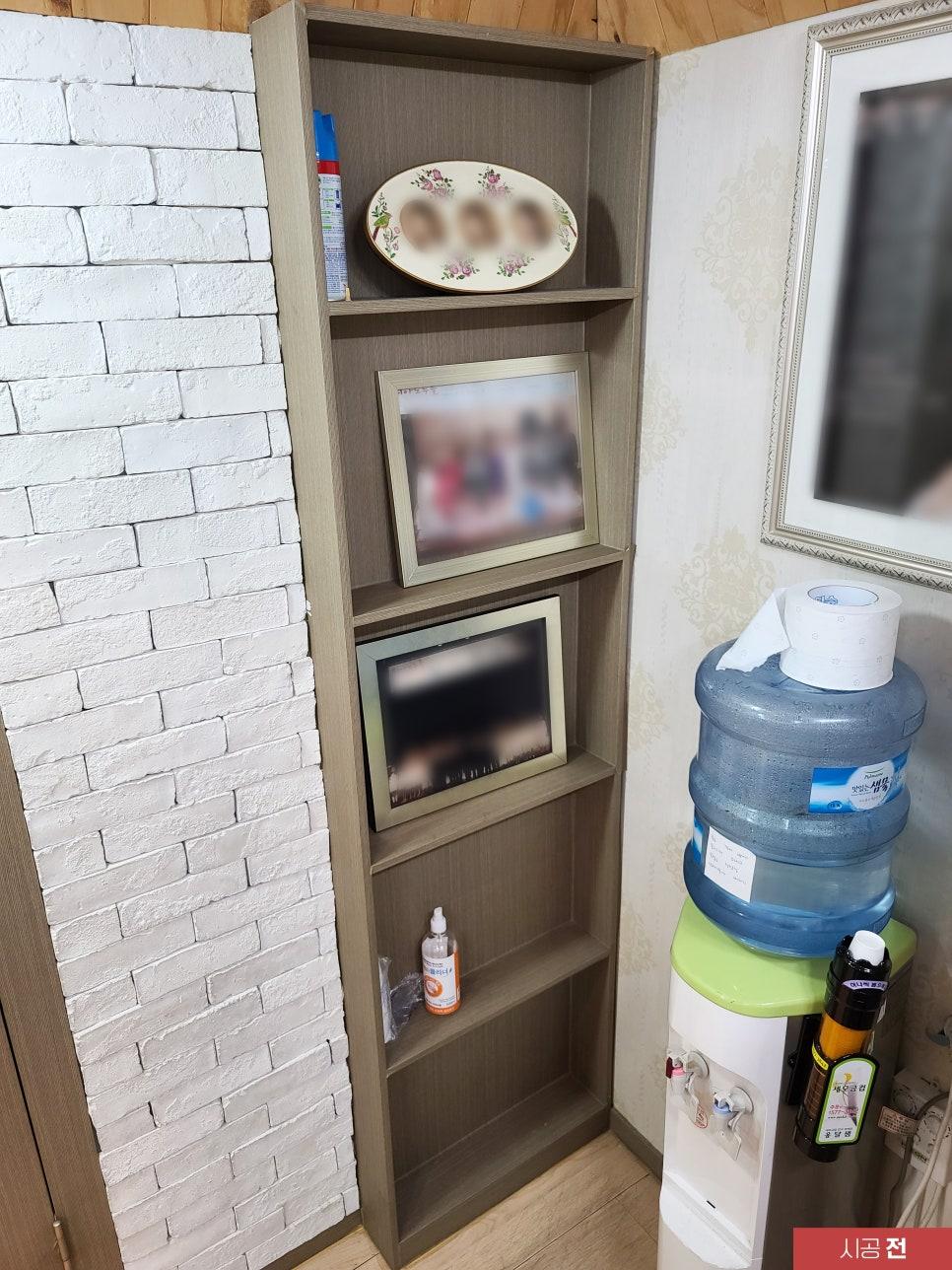 어두운 우드톤 붙박이장과 흰색 벽돌 벽의 조화