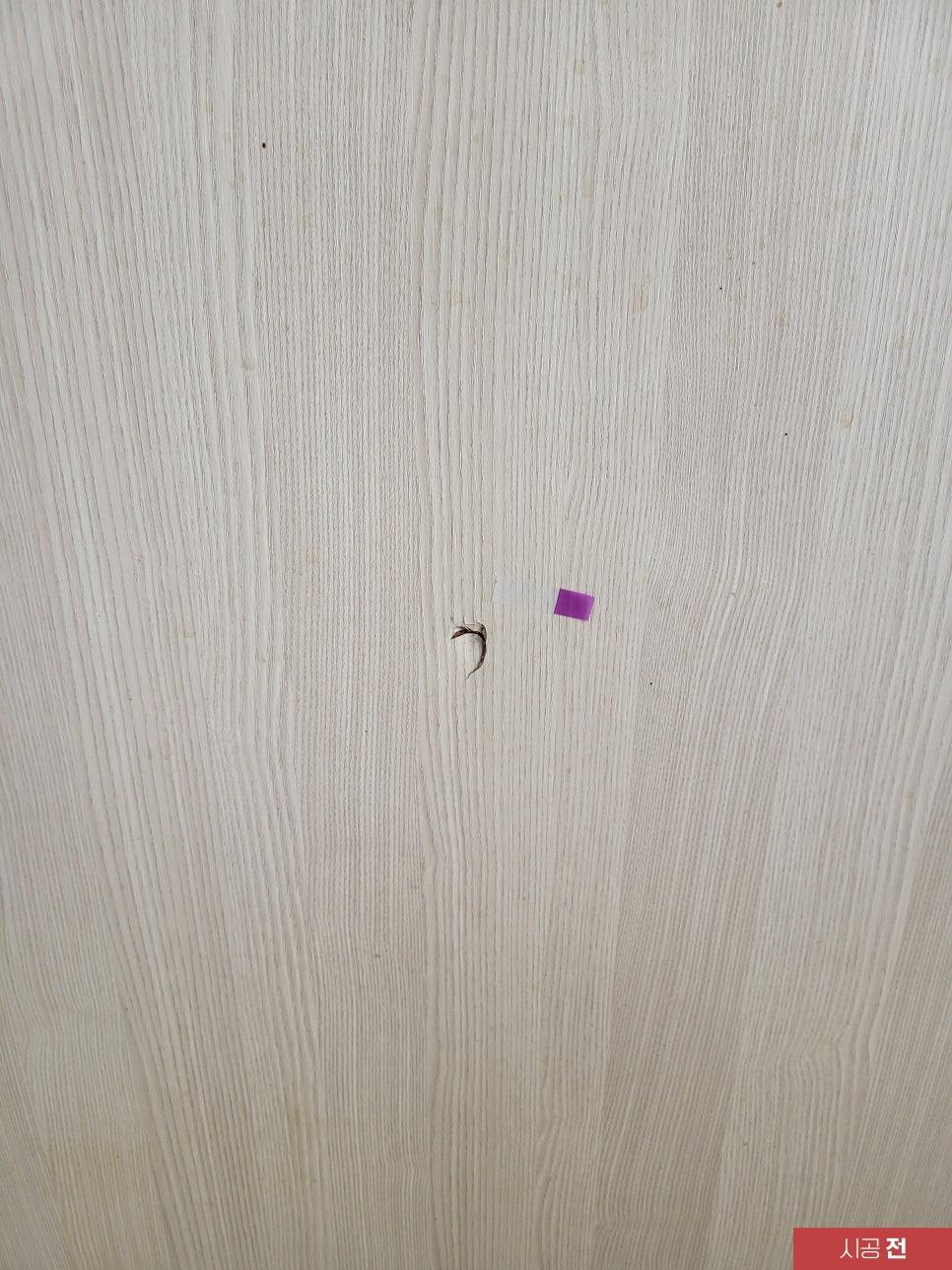 회색 목재 패턴 표면의 구멍과 보라색 스티커 디테일