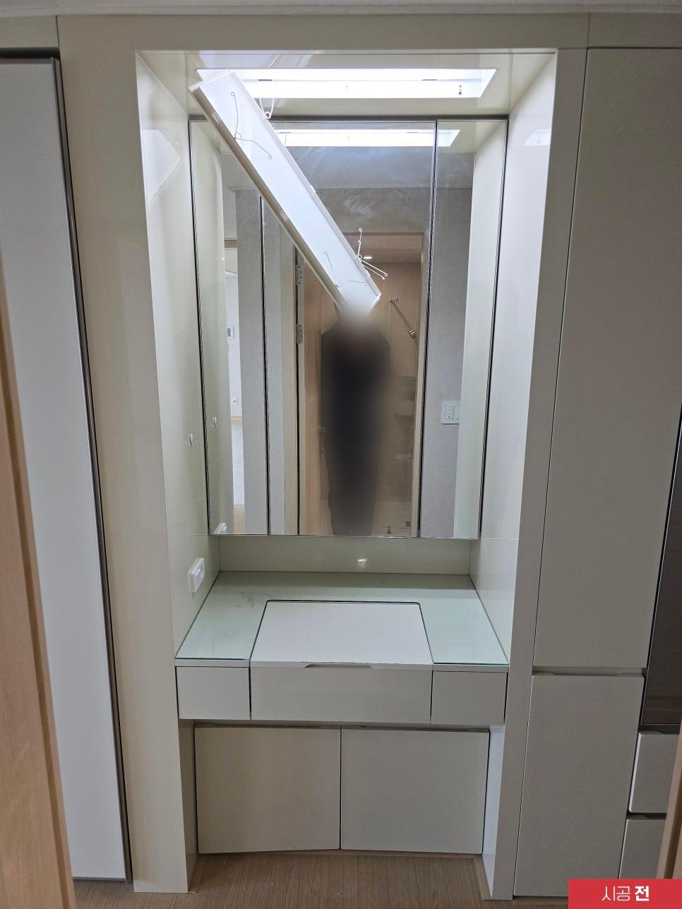 거울과 수납장이 있는 화장실 공간 시공 중