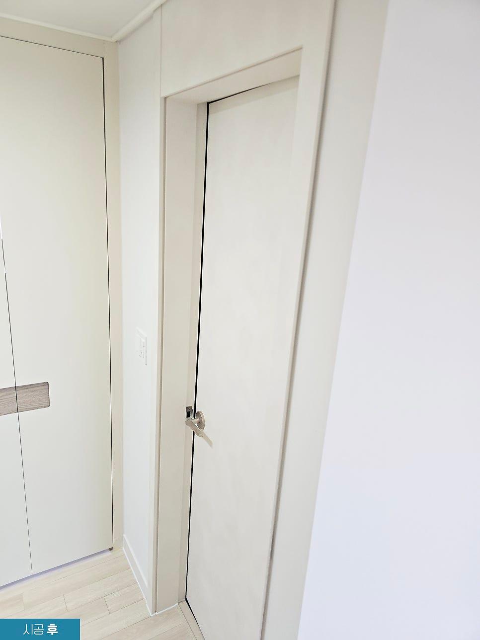 힌지가 보이는 여닫이 도어 상부의 필름 마감