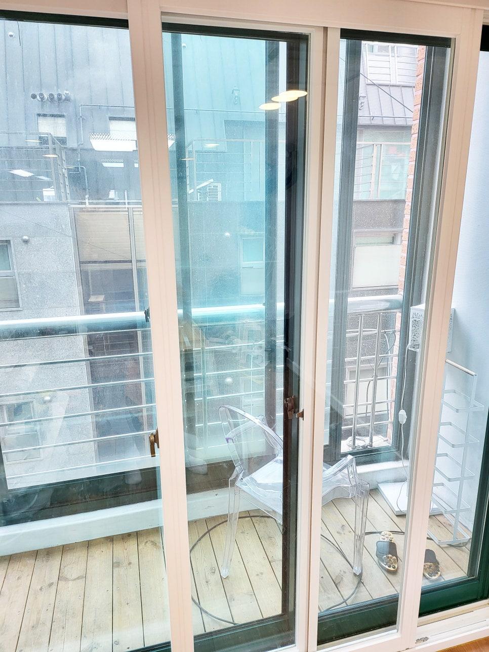 목재 바닥과 유리문으로 구성된 발코니 공간