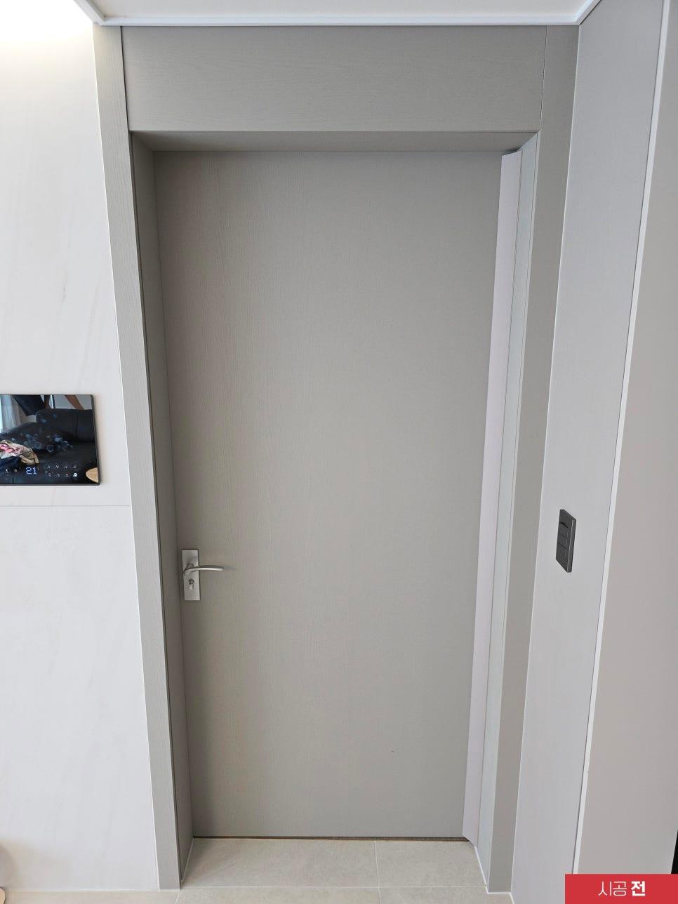 회색 도어가 설치된 시공 전 현관 공간