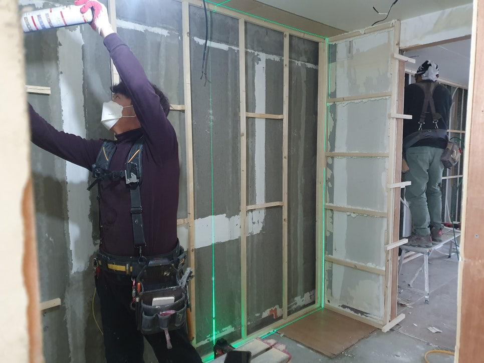 목재 프레임과 흰색 마감재가 설치된 작업 현장
