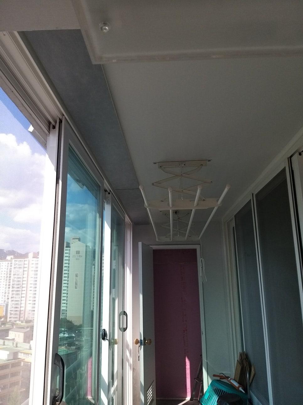 천장 조명 구조물과 보라색 도어가 보이는 발코니