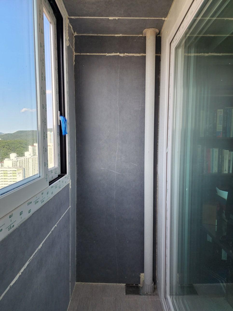 검은색 마감재와 흰색 배관이 설치된 타일 바닥 발코니