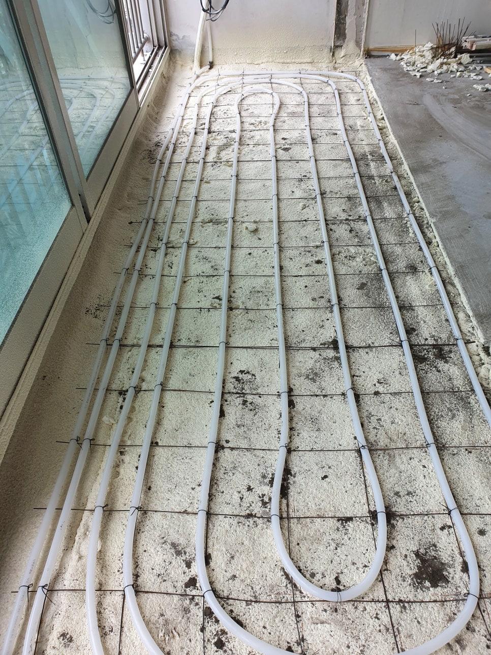 철근망 위에 고정된 백색 PVC 난방 배관