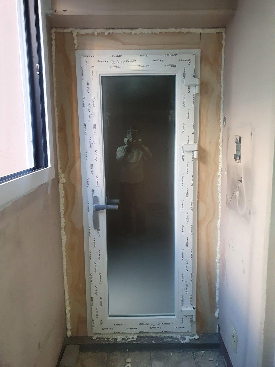 베이킹 보드와 도어 프레임이 설치된 현관 벽면
