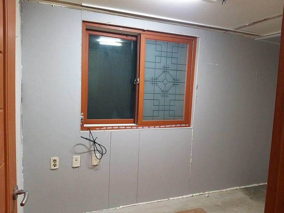 갈색 프레임 창호와 벽면의 전기 소켓 및 케이블