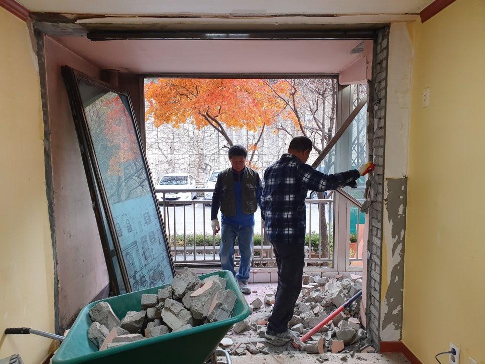 벽지가 벗겨지고 콘크리트가 드러난 현관 철거 현장
