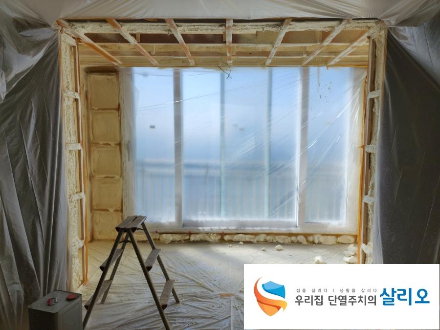 목재 프레임과 보라색 테이프가 감싸진 창호 구조