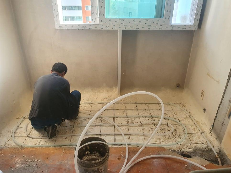 바닥에 금속 격자와 파이프를 배치하고 코팅 작업 중인 실내