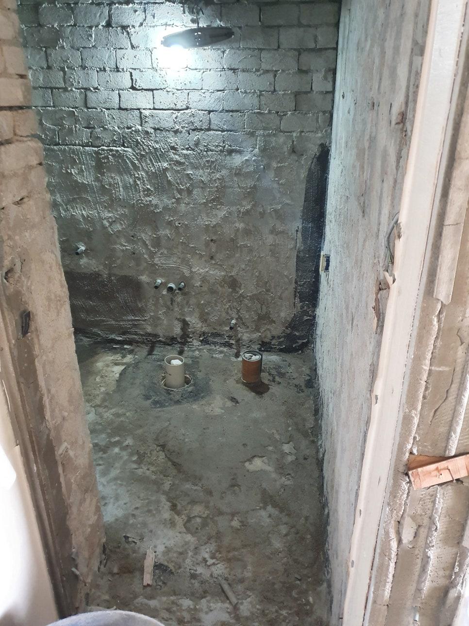 배관 구멍이 보이는 콘크리트 벽과 바닥의 노출 상태