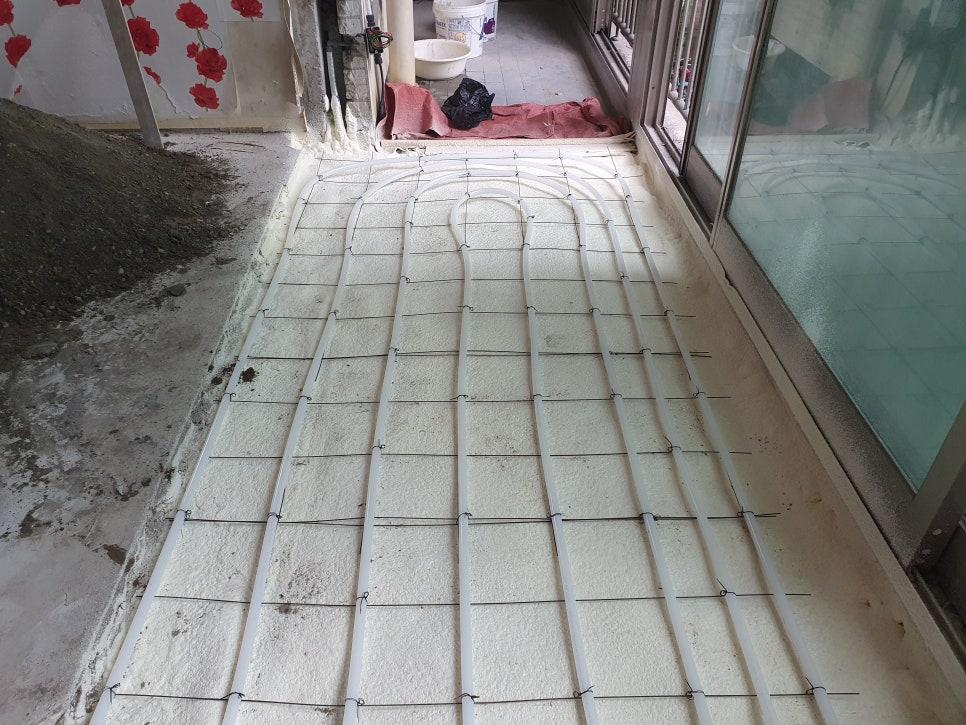 바닥에 설치된 백색 배관망과 금속선