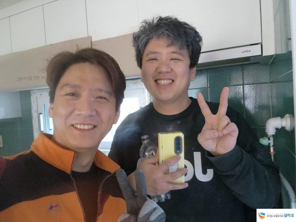 녹색 타일 벽과 화이트 냉장고가 배치된 주방