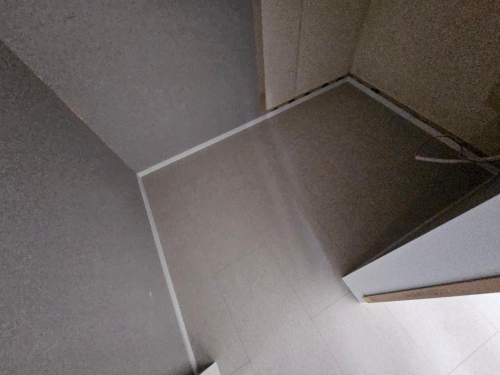 회색 타일 바닥과 벽면 접합부의 흰색 실선