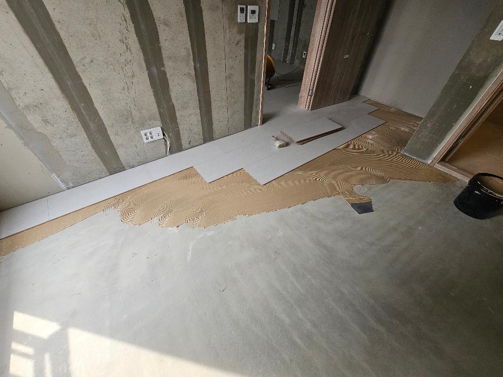 타일 시공 중인 벽면과 전기 소켓