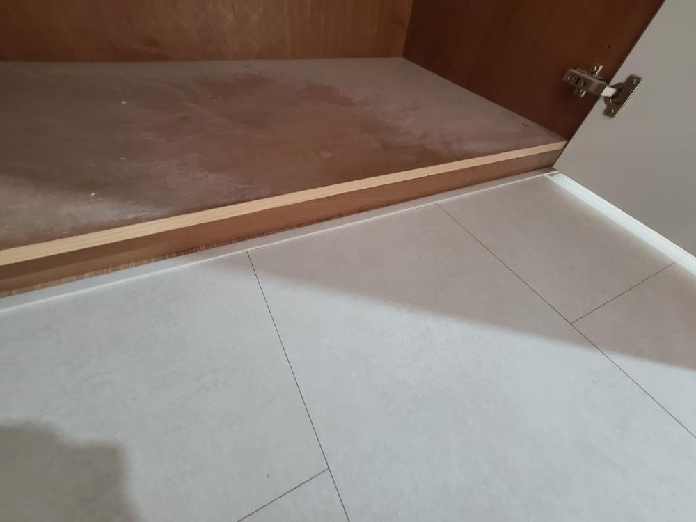 수납장 하단까지 채워진 우드톤 바닥재