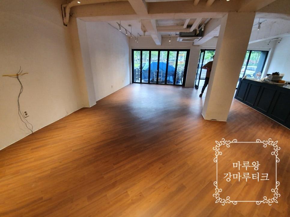노출 천장 구조와 사선으로 시공된 우드톤 마루