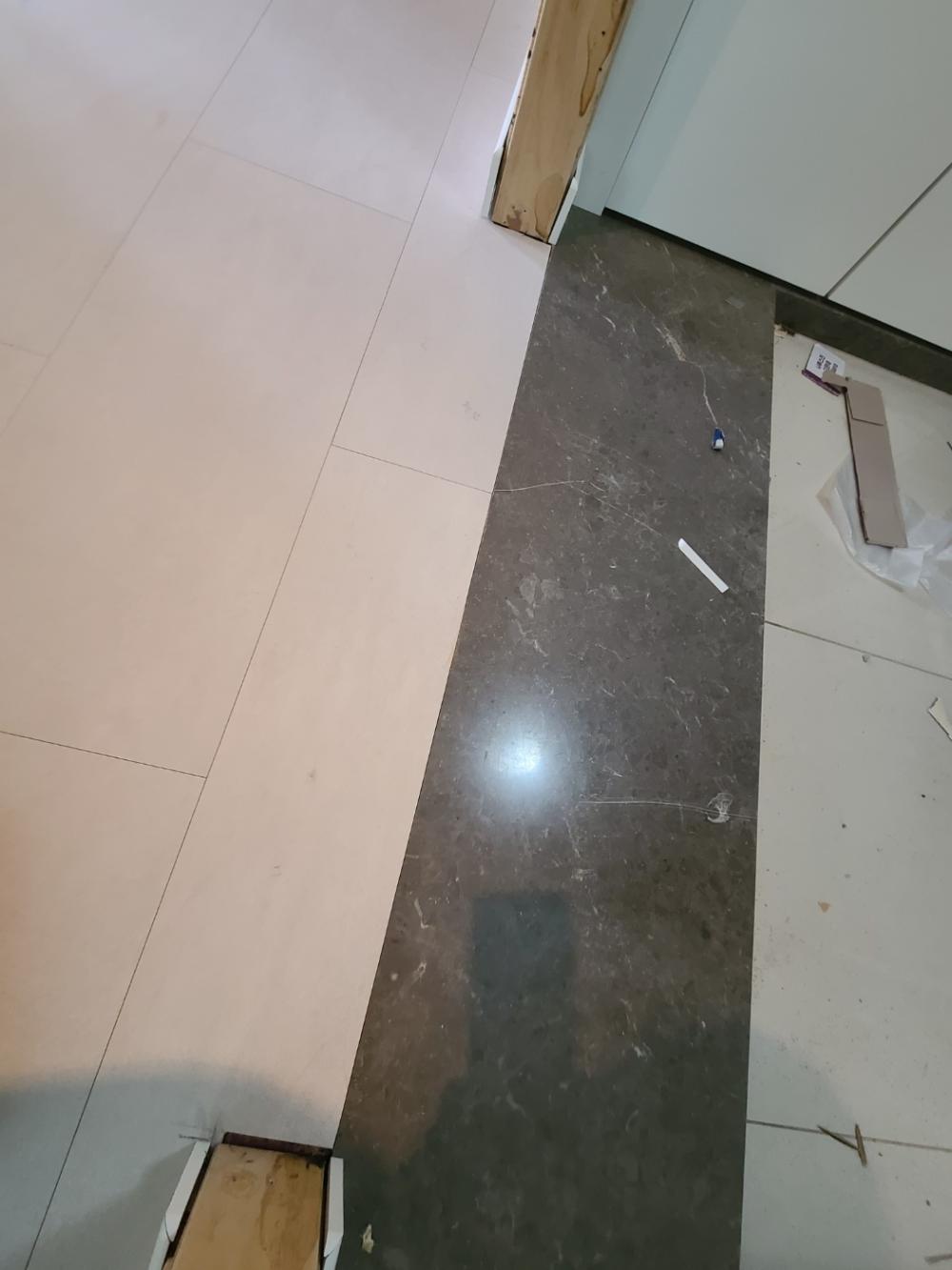 흰색과 갈색 타일이 이어지는 바닥 경계면