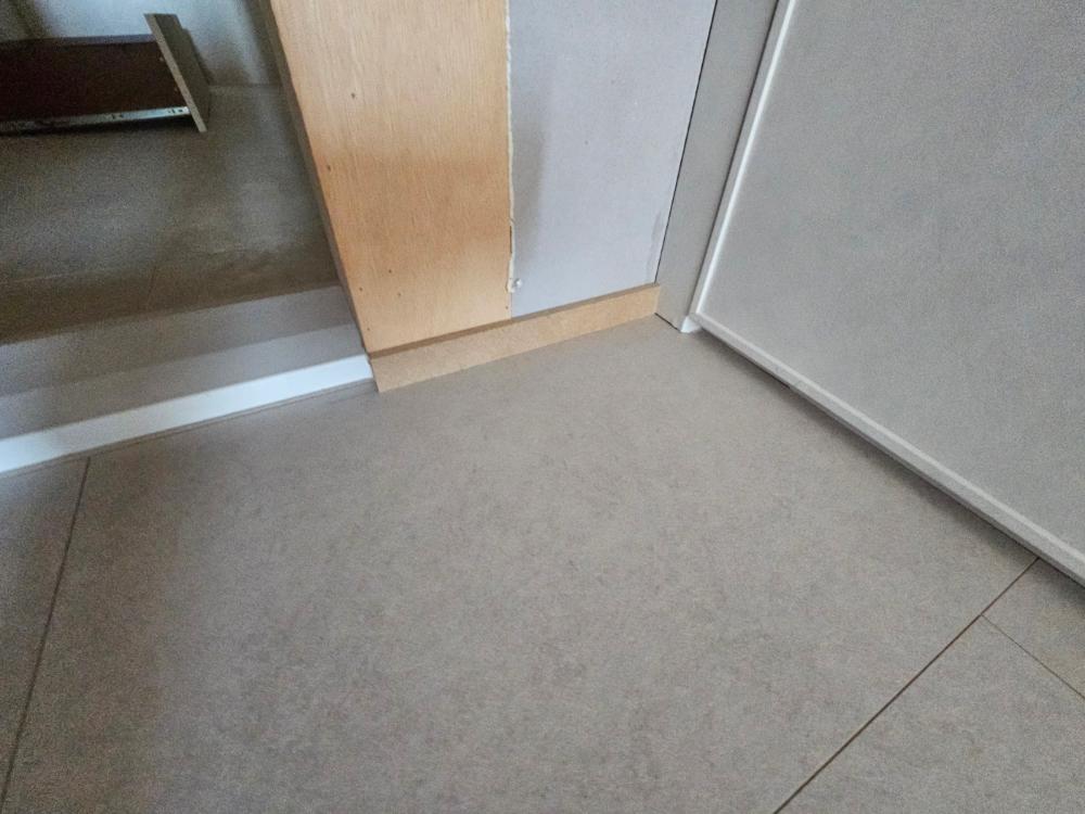 회색 타일과 베이지 벽면, 목재 수납장이 어우러진 모습