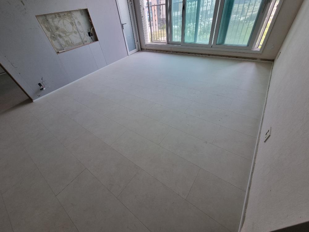 벽면 구멍과 창문이 보이는 타일 바닥 공간